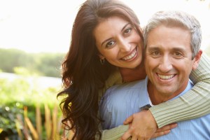 happy couple embracing outside smiling